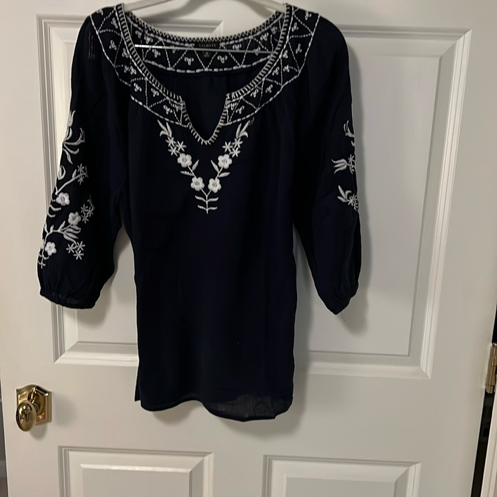 Talbots generously size M. Great with white shorts, white skirt, or blue jeans!